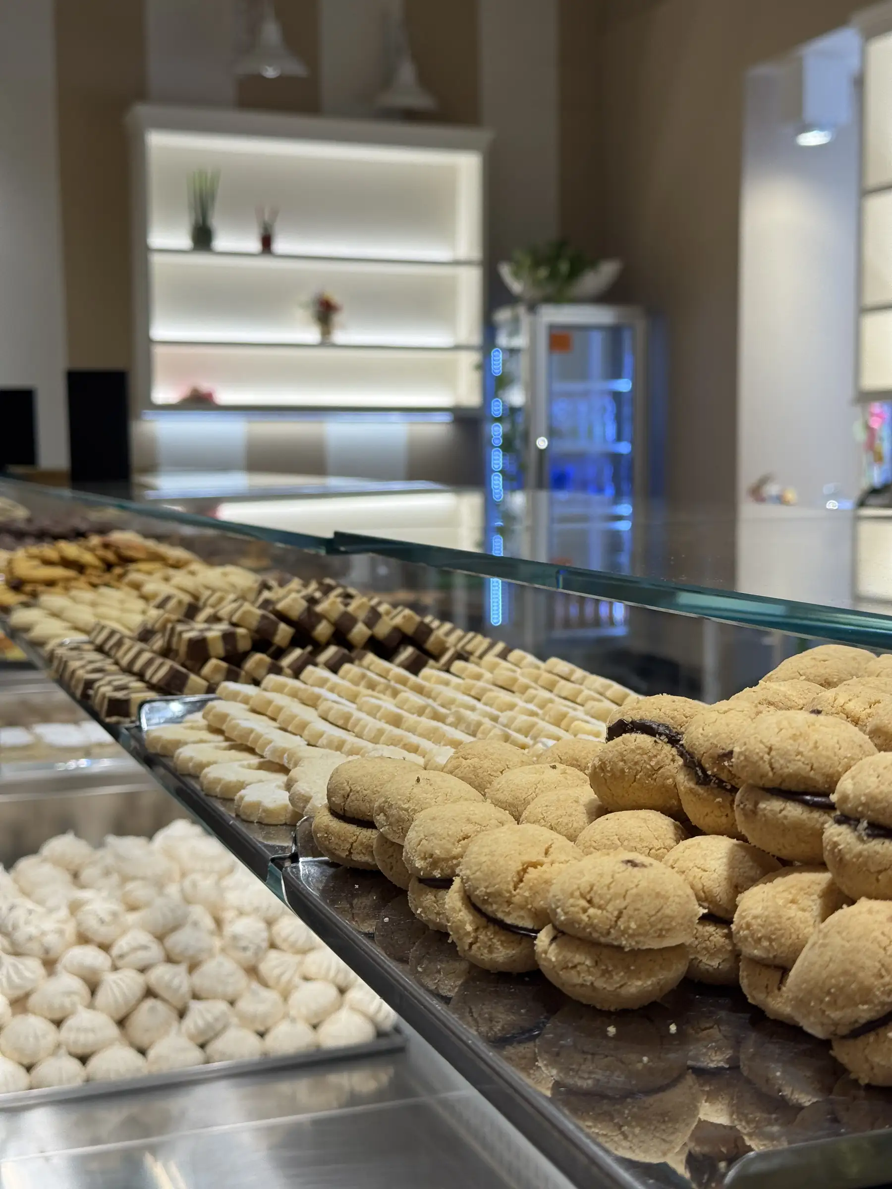 Il banco della biscotteria assortita: vassoi di biscotti secchi, paste di meliga e dolcetti al cioccolato
