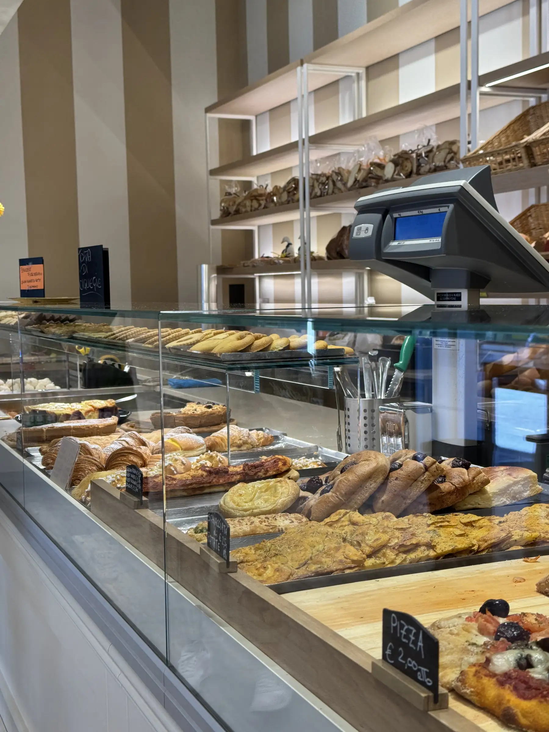 Il banco del salato con pizze, focacce e le teglie del pranzo del giorno